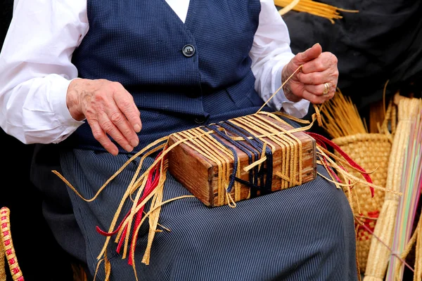 Gerimpelde handen van een bejaarde vrouw terwijl draai het stro te crea — Stockfoto