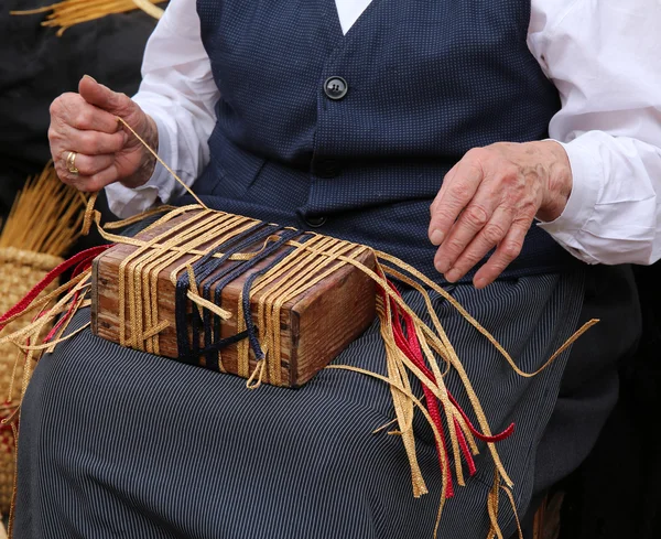 Manos arrugadas de una anciana mientras crea un str hecho a mano — Foto de Stock