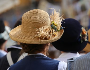 bir kalabalığın içinde Mısır kulakları ile hasır şapkalı kadın