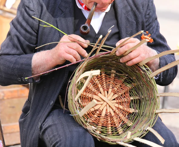 Gammal man röka sin pipa skapar en halm korg — Stockfoto