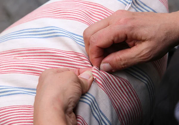 Руки пожилой женщины при шитье иголочкой и втроем — стоковое фото