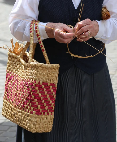 Mulher idosa com saco de palha andando — Fotografia de Stock