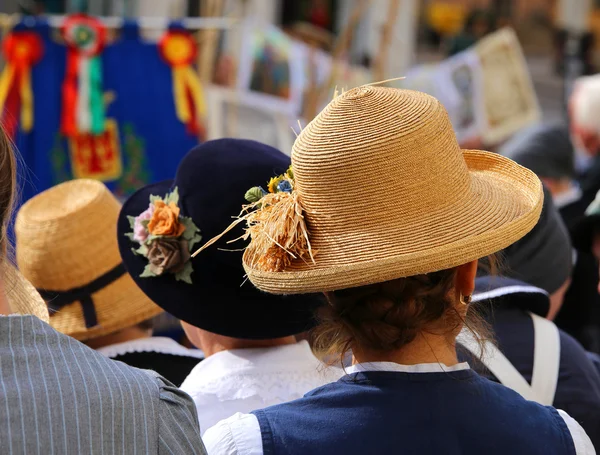 Woman with straw hat with ears of corn in a crowd — Stock Photo, Image