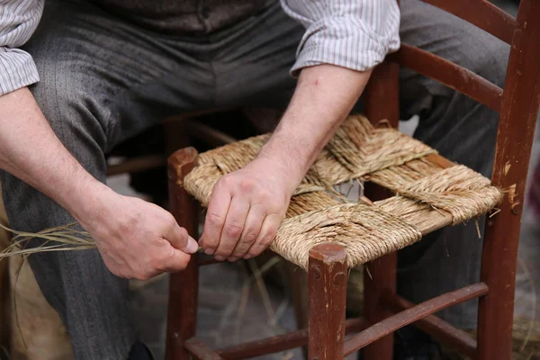 Mender of chairs while repairing a old  wooden chair — Stock Photo, Image