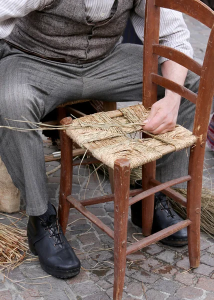 mender of chairs while repairing a chair