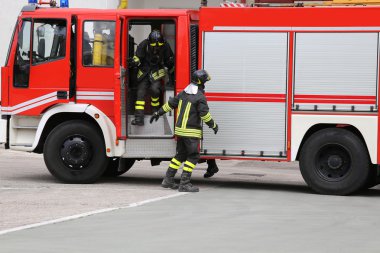 Yanan binanın önünde kırmızı itfaiye çekti.