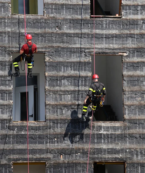 Bold and daring climbers of firefighters climbing a wall — Stock Photo, Image