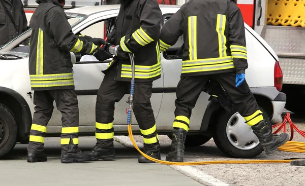 Bombeiros corajosos aliviar um ferido após um acidente de viação — Fotografia de Stock