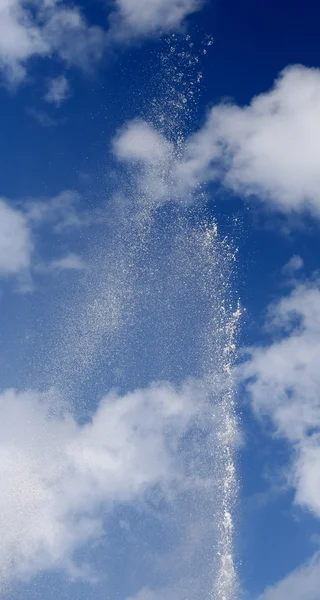 Vysokým vodním paprskem na pozadí modré oblohy s bílým clou — Stock fotografie