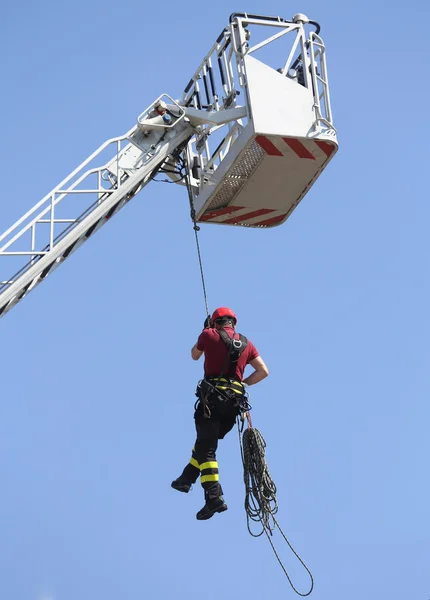Brandman hängde rep klättring i firehouse — Stockfoto