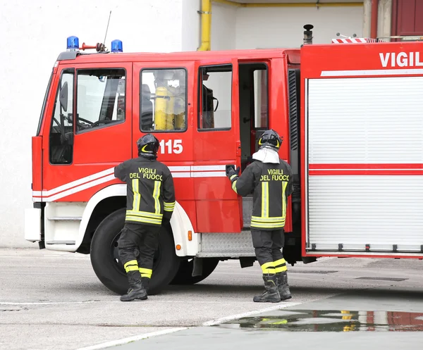 Two Italians firefighters descend from fire trucks — Stock Photo, Image