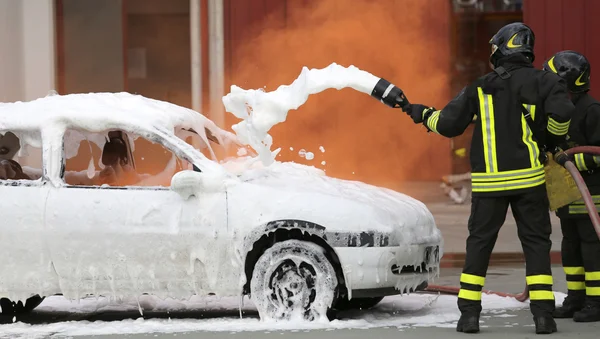 Bombeiros durante o exercício para extinguir um incêndio em um carro — Fotografia de Stock