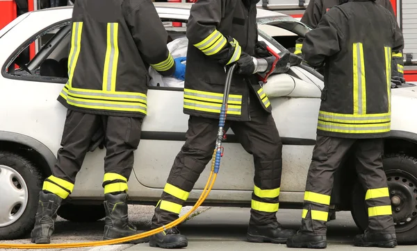 Pompiers courageux soulager un blessé après un accident de la route — Photo