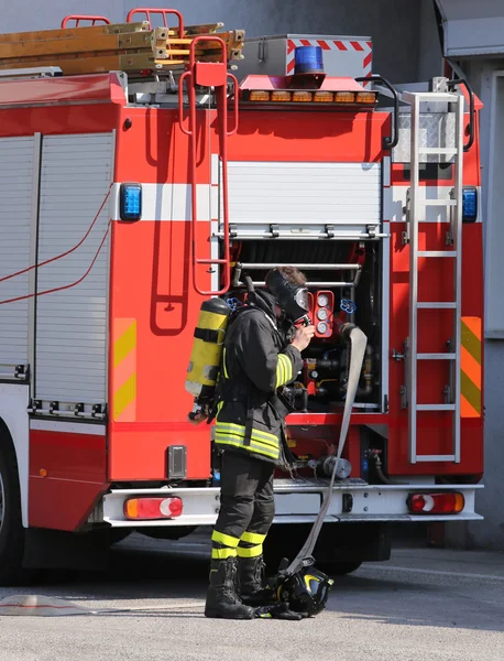 Brave firefighters with fire engine truck during an exercise — Stock Photo, Image