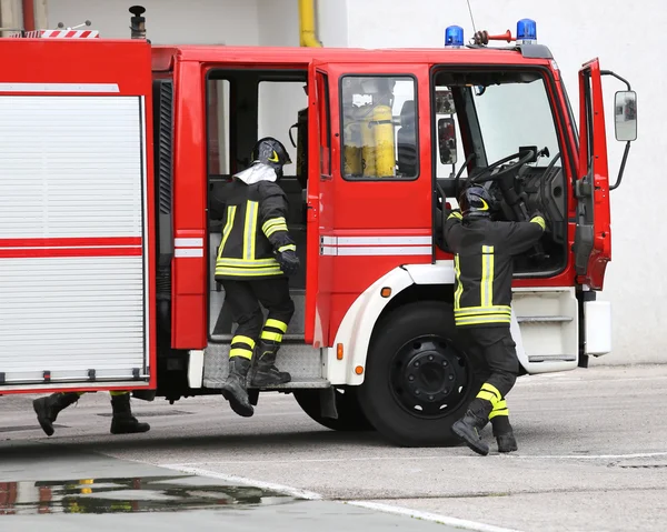 Fire engine with many firefighters and equipment for fighting fi — Stock Photo, Image