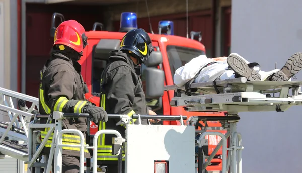 Bomberos en la cesta del camión de bomberos salvar a la persona herida wi —  Fotos de Stock