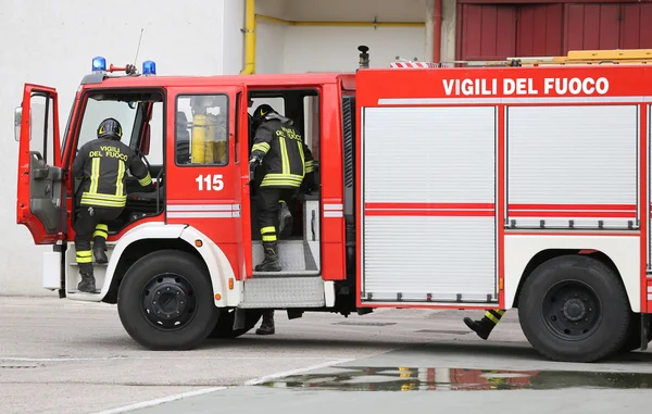 Brandweerwagen uitvoering van twee brandweerlieden — Stockfoto