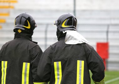 iki itfaiye stadyumda miğferli