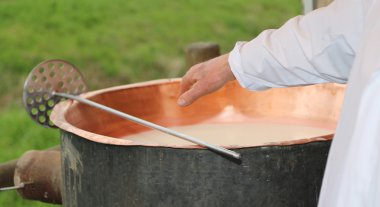 Cheesemaker el ile c iç sütün sıcaklığı denetler.