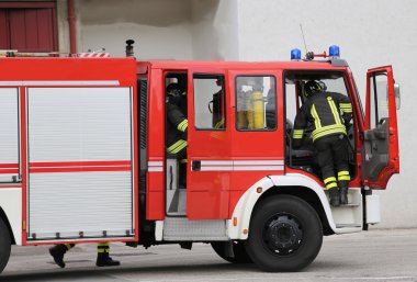 İtfaiyeciler, hızlı bir şekilde firetrucks inerler