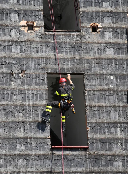 Wspinacz dzielnych strażaków rappelling ściany — Zdjęcie stockowe