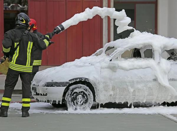 Bombeiros durante o exercício para extinguir um incêndio em um carro — Fotografia de Stock