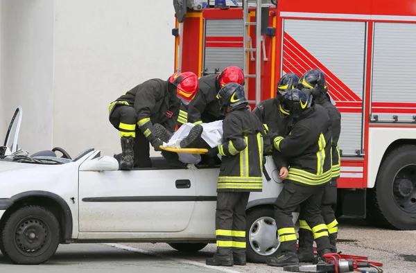 Bomberos alivian un herido después de accidente de coche —  Fotos de Stock