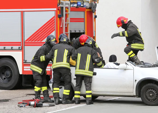 Pompiers soulager un blessé après un accident de voiture — Photo