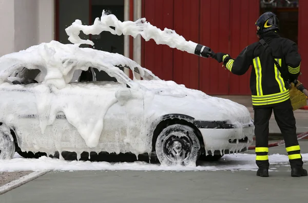 Bombeiros durante o exercício para extinguir um incêndio em um carro — Fotografia de Stock