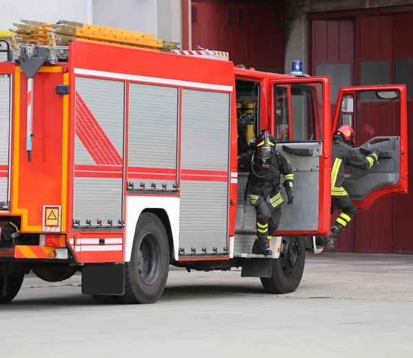 Löschfahrzeug mit vielen Feuerwehrleuten und Ausrüstung zur Brandbekämpfung — Stockfoto