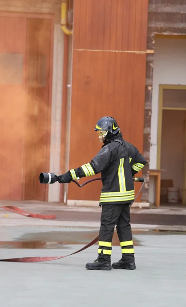 Brandman med slangen kämpar tjänster — Stockfoto