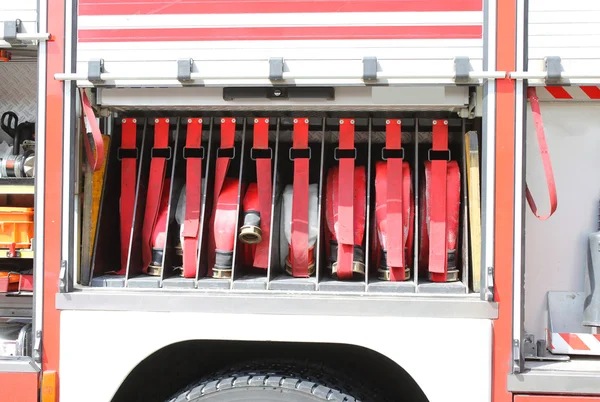 Big red fire truck hoses fighting services in fire truck — Stock Photo, Image