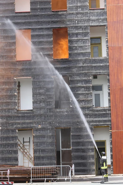 Bomberos con fuego durante la práctica en la estación de bomberos — Foto de Stock