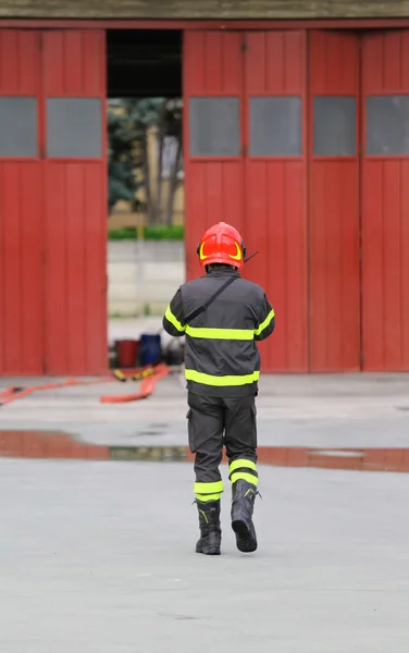 Bombeiros em uniforme com capacete vermelho — Fotografia de Stock