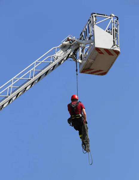 Bombeiro pendurou a corda subindo no quartel de bombeiros — Fotografia de Stock