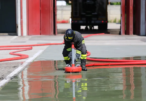 Bombero posiciona una potente boca de incendios —  Fotos de Stock