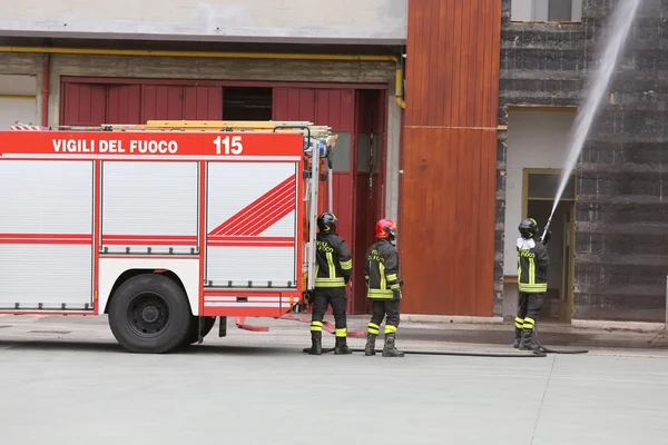 Пожежний двигун піднятий перед палаючою будівлею — стокове фото