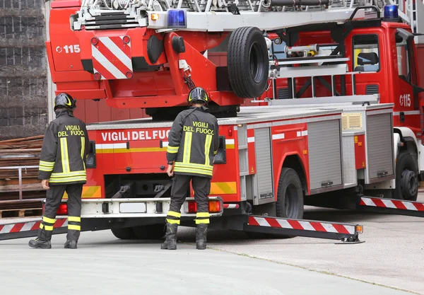 Carro de bombeiros parado em frente ao edifício em chamas — Fotografia de Stock