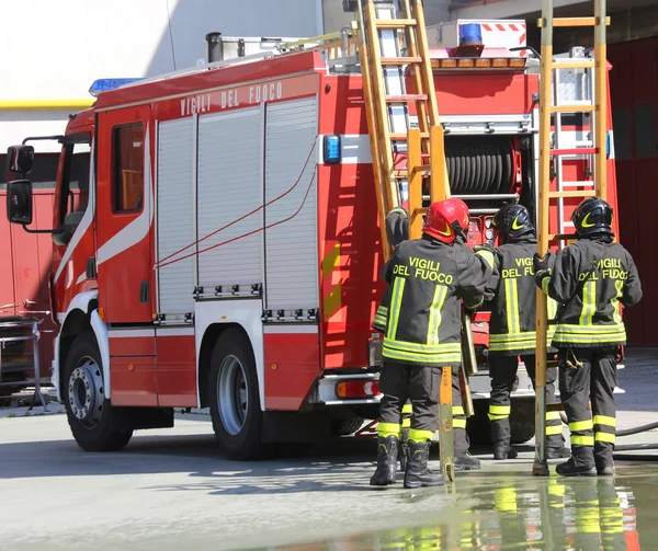 Bombeiros em ação tomar a escada de madeira do caminhão de bombeiros — Fotografia de Stock