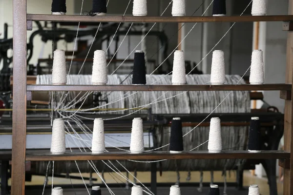Катушки нити для вращения в старом промышленном ткацком станке — стоковое фото