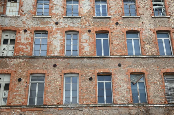 Industribyggnad med riktad tegelstenar och trasiga fönster — Stockfoto