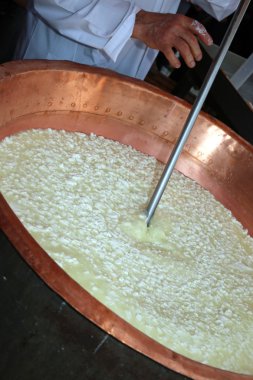 uzman cheesemaker m Bakır kazan içine lor kıpırdanırken