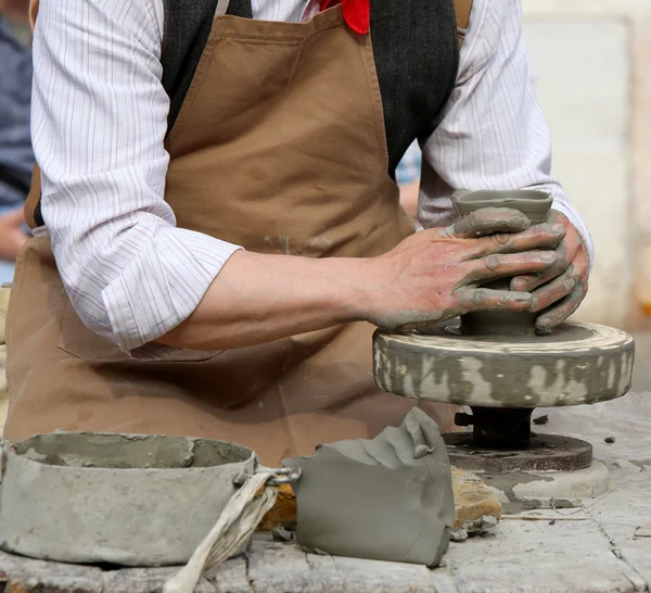 Potter con el torno de mano durante la producción de una olla — Foto de Stock