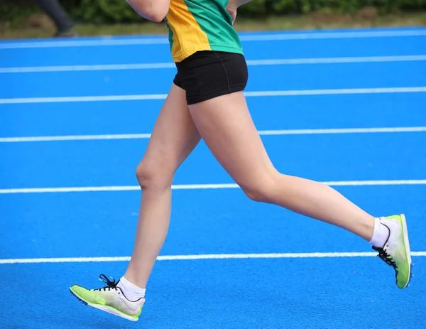 年轻的女运动员腿跑在田径跑道 — 图库照片