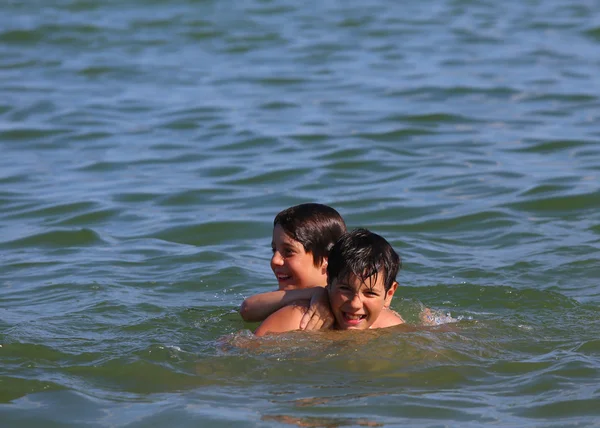 Δύο νεαρά αδέλφια που παίζει στο νερό της θάλασσας — Φωτογραφία Αρχείου
