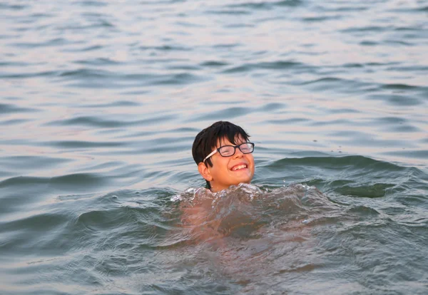 Pojke med glasögon spelar i havsvatten under sommarlovet — Stockfoto