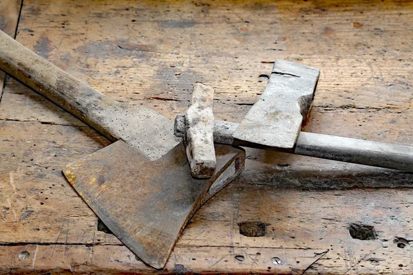 Small axe and big hammer on the old wooden workbench — Stock Photo, Image