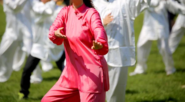 ピンクのシルクのドレスの女性が公園で演習を実行します。 — ストック写真