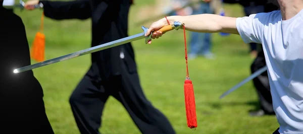 Tai Chi martial arts athlete expert makes motions with sword — Stock Photo, Image