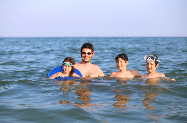 父と海で遊んで子供 3 人と幸せな家庭 — ストック写真